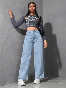 Détail d'un jean large à taille haute porté avec un ensemble débardeur court à motif