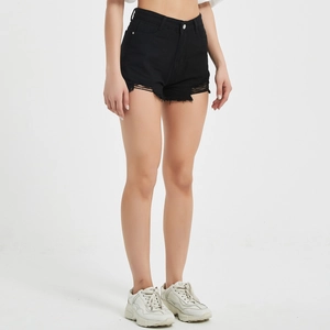 Detail of high-waisted black denim shorts featuring raw hems and distressed street style