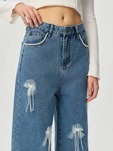 Detail von High Waist Denim Jeans mit Perlenbesatz und Mesh Schmetterlingsquasten