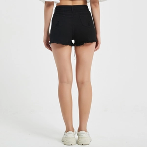 Detail of high-waisted black denim shorts with frayed edges and distressed back pockets