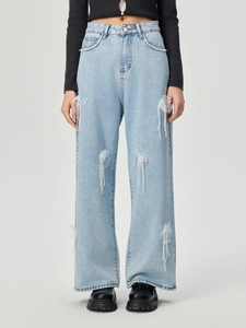 Detail der hellblauen Wide-Leg-Jeans mit Netzschleifen und hängenden Perlenverzierung