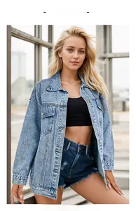 Close-up of oversized light blue washed denim jacket with metal buttons and flap pockets