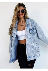 Detail of light blue washed denim jacket with ripped accents and chest pockets