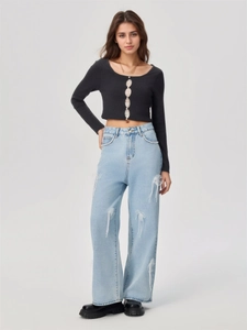 Detail der hellblauen Wide-Leg-Jeans mit Perlenschnüren und weißen Netz-Schleifen