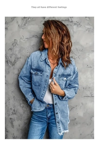 Detail of light blue washed denim jacket with vintage frayed hem and chest pockets