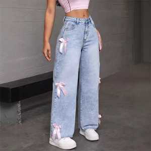 Jeans larghi azzurri con fiocchi in raso rosa sui lati e taglio a vita alta