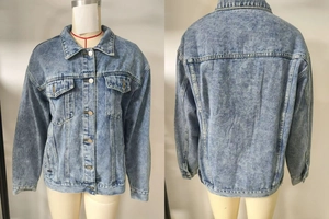 Detail of light blue acid wash denim jacket showing classic lapel and flap pockets