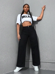 Détail d'un pantalon noir taille haute à jambes larges et crop top graphique Melanin