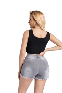 Détail des bords effilochés et de l'ourlet sur un short en jean taille haute usé