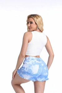 Detail of light blue tie-dye denim shorts featuring frayed tassel hems and a slim fit cut