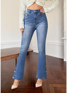 Detail of high waist flare jeans featuring vintage button accents at the side of the cuffs