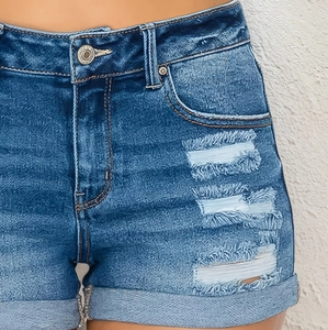 Close-up of classic blue denim shorts with distressed ripped detail and cuffed hem finish