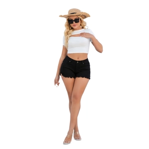 Detail of summer low waist black denim shorts with ripped hem and frayed edges