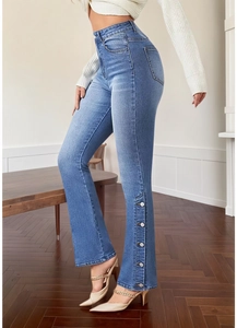 Detail of blue flared jeans showing five silver metal buttons on the side leg opening
