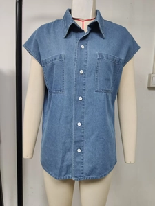 Detail of dark blue denim shirt featuring large chest pockets and button-down front
