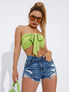 Détail de short en jean taille basse vieilli avec ourlets effilochés et déchirures