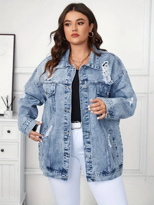 Detailed close-up of light blue distressed denim jacket with vintage ripped effects