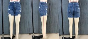 Détails de l'ourlet effiloché et des trous sur ce short en jean bleu foncé taille basse