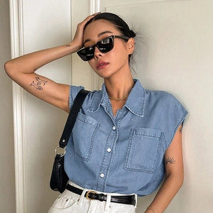 Women's light blue sleeveless denim shirt with chest pockets and washed finish