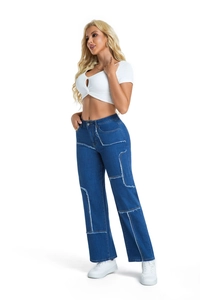 Detailed close-up of high-waist patchwork denim jeans with contrast fringe stitching