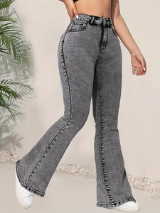 Détail d'un jean évasé à taille haute gris délavé avec une texture effet neige