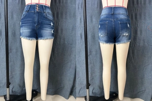 Détail du short en jean taille haute avec fermeture à trois boutons et ourlet effiloché