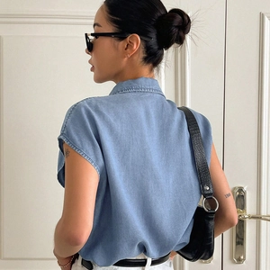 Light blue denim sleeveless button-down shirt with turn-down collar and loose fit design