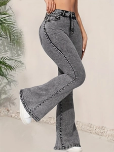 Détail d'un jean évasé gris à taille haute avec effet délavé et ourlets effilés