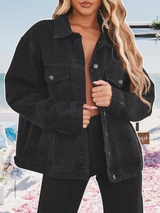 Close-up of oversized black denim jacket with metallic buttons and flap pockets
