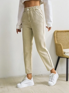 Close-up of khaki high-waisted jeans with elastic waistband and metal button detail