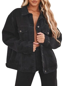 Detail of loose fit black denim jacket with silver metal buttons and flap pockets