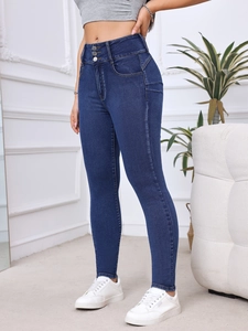 Detail view of high waist skinny jeans with triple-button closure in dark blue denim