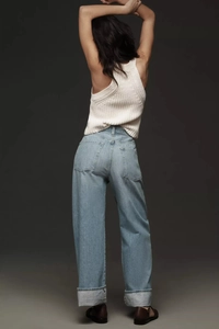 Rear view of high-waisted wide-leg light blue jeans with stylish cuffed hem detail