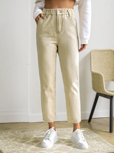 Detail of high waist beige cropped jeans with elastic waistband and metal button closure
