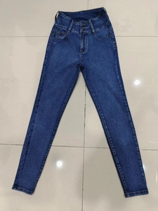 Detailed view of high-waisted dark blue skinny jeans with three metal buttons and slim fit