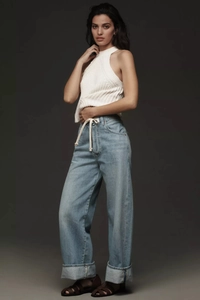 Close-up of light blue wide-leg jeans featuring white rope belt and oversized folded cuffs