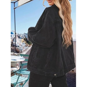 Chic black oversized denim jacket for women featuring drop shoulders in a sunny outdoor setting