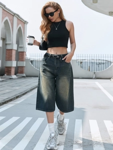 Outdoor street style shot of women's vintage wash wide leg denim culottes with black crop top