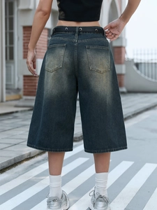 Detail view of vintage wash wide-leg denim culottes with classic back pockets and belt