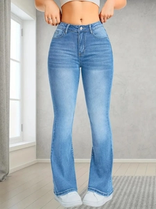 Detailed view of high-waist flare jeans featuring vintage whiskers and faded wash effect