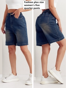 Detail of high-waist denim shorts showing elastic waistband and vintage washed blue texture