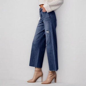 High-waisted dark blue wide-leg denim jeans with distressed details and raw hem