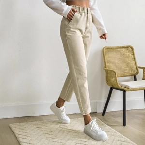 Beige high-waisted cropped straight-leg denim jeans with an elastic waist shown from the side
