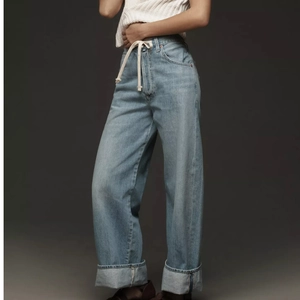 Women's light blue wide-leg high-waisted jeans with drawstring waist and cuffed hem