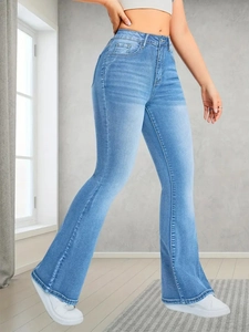 Detail of light blue high-waisted flare jeans showing slim fit cut and washed denim fabric