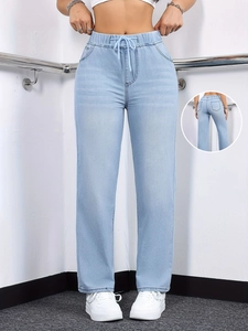 Detail of light blue washed straight-leg jeans with drawstring waist and elastic waistband