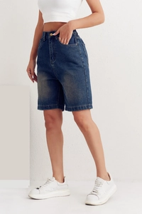 Detail of mid-waist blue denim shorts featuring elastic waist and washed fabric texture