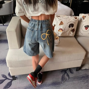 Short en jean bleu clair à taille haute avec nœuds jaunes sur les poches arrière