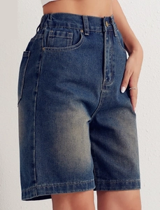 Detail view of high-waist dark blue denim shorts featuring elastic waistband and pockets