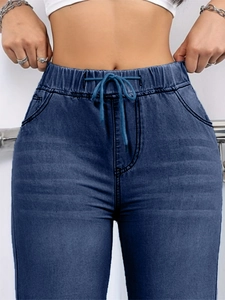 Close-up of drawstring elastic waistband and washed denim texture on blue jeans